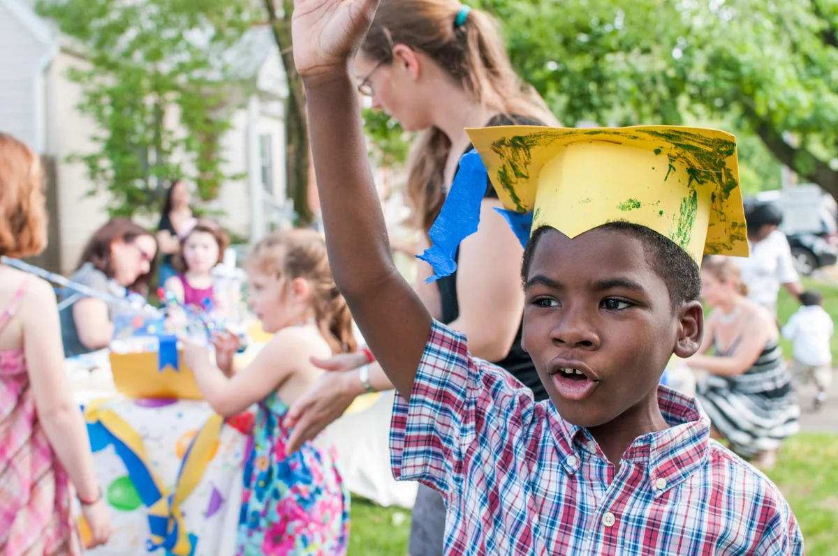 little boy in painted paper grad hat