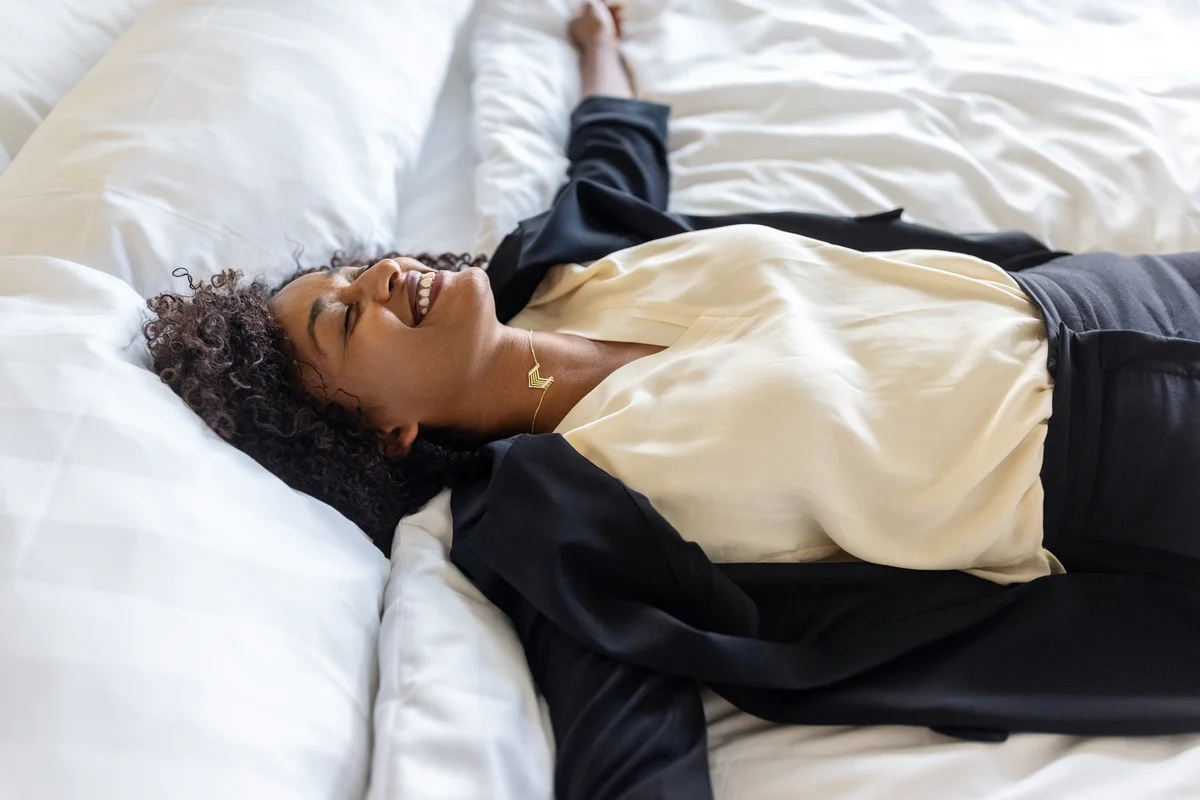 Woman laying happily in bed