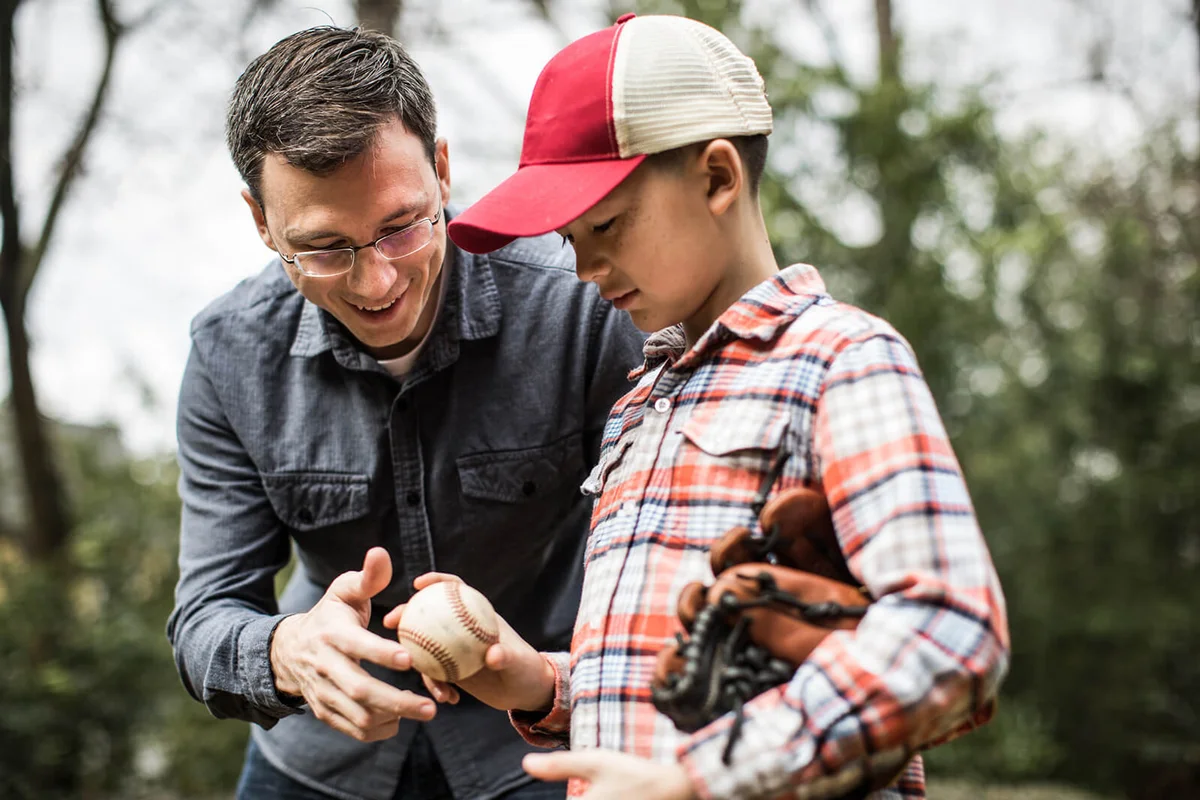 Father teaching son to throw a baseball