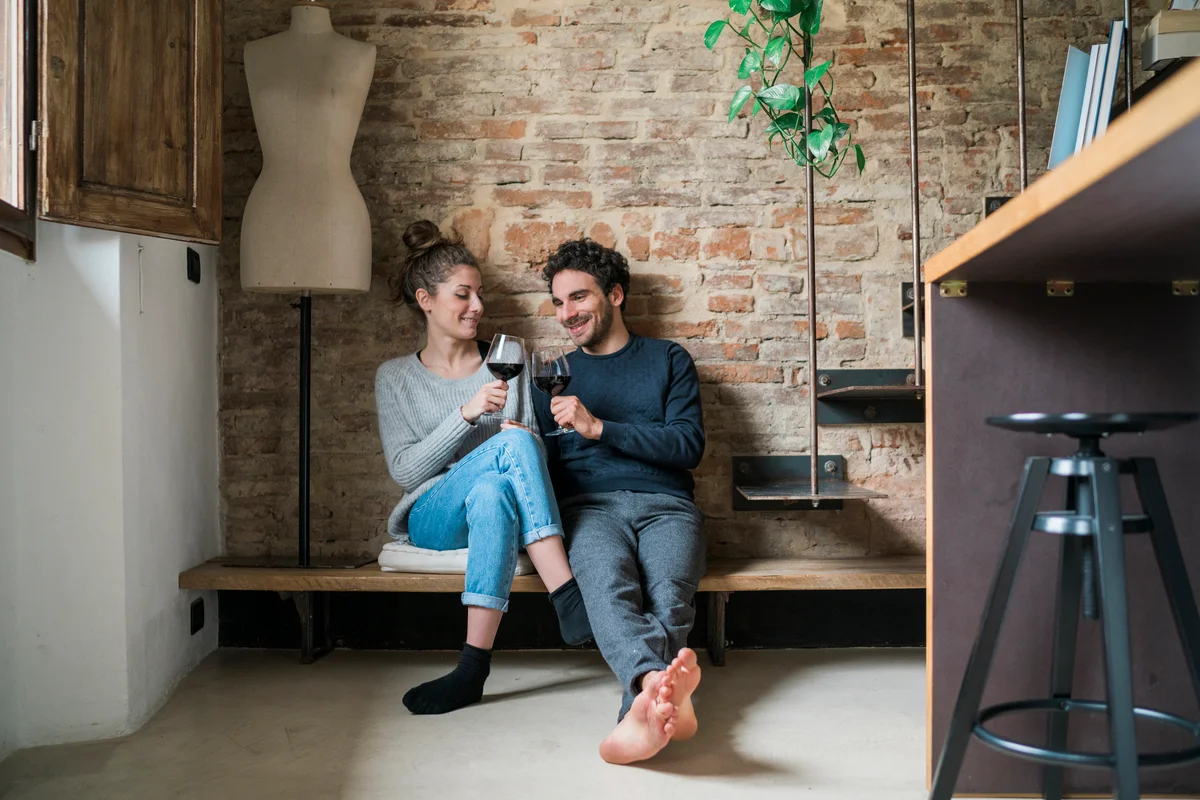 Young couple raising a toast on kitchen bench