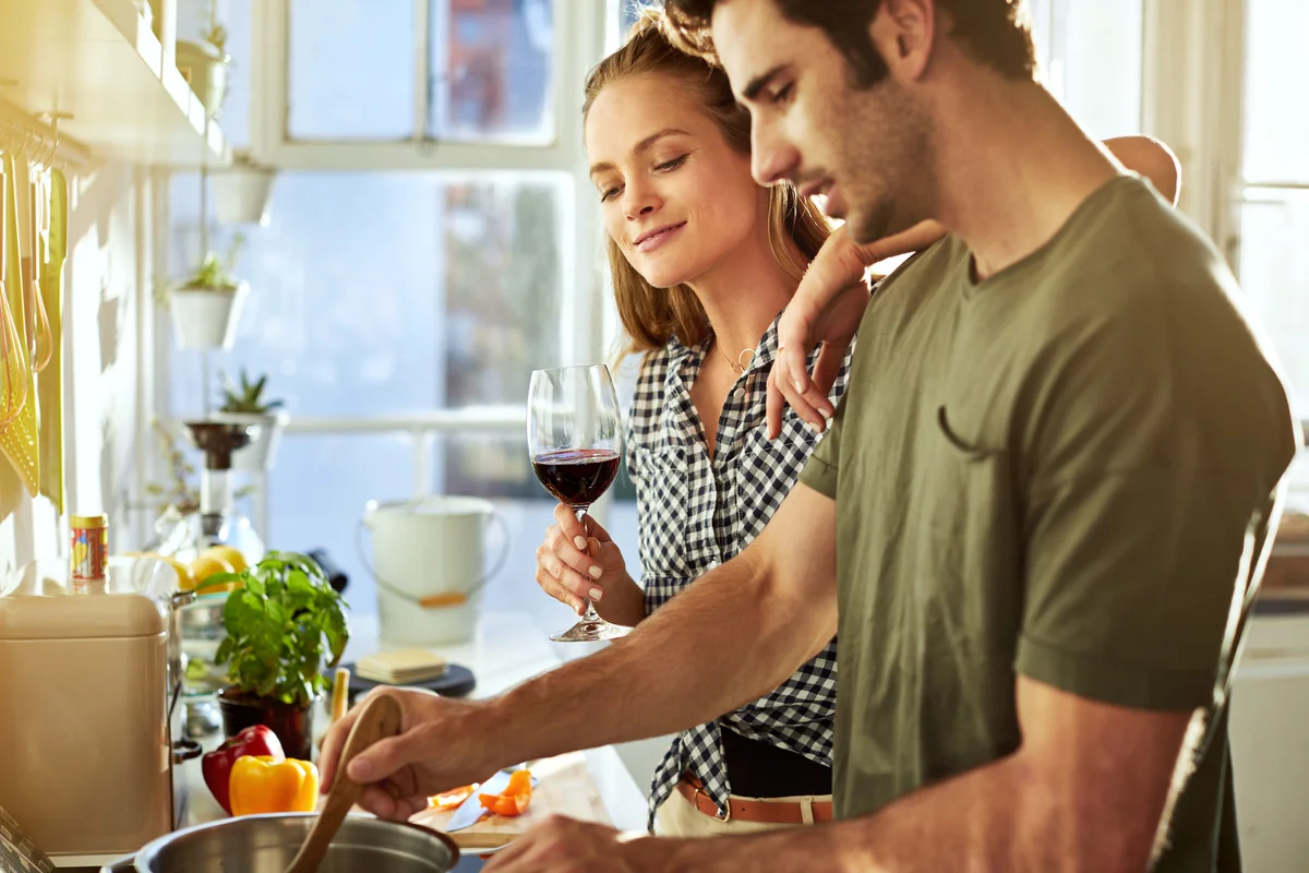Couple cooking and having glass of wine