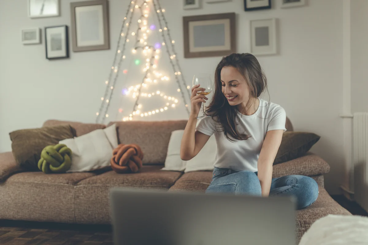 Woman sitting on couch and enjoying glass of wine