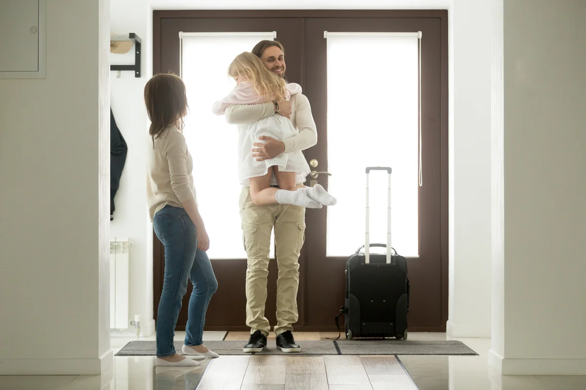 Dad greeting children with suitcase