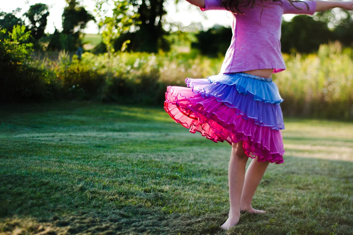 little girl wearing a colorful ruffled skirt