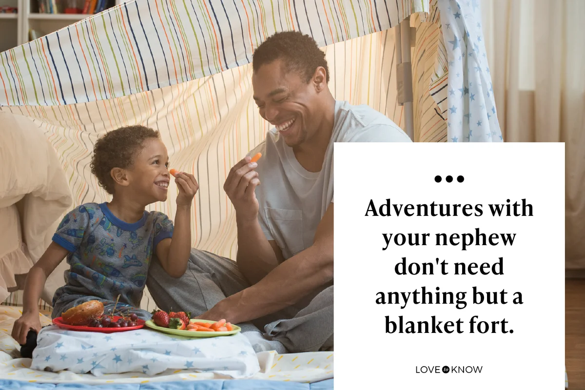Father and son eating in blanket fort
