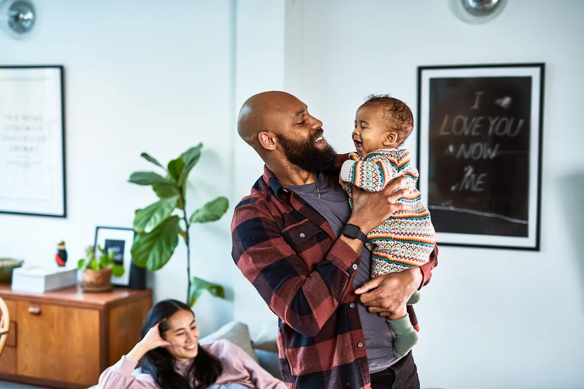 Cheerful uncle holding happy baby nephew