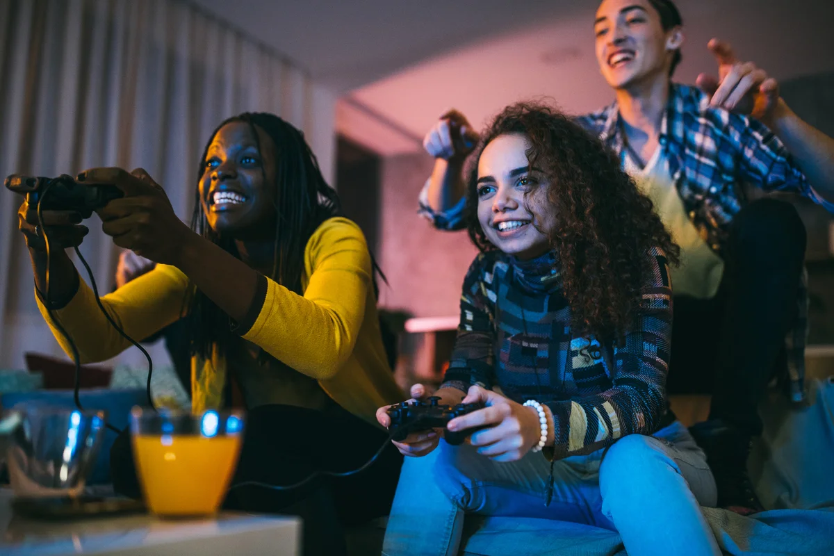 Friends having fun playing video games at night