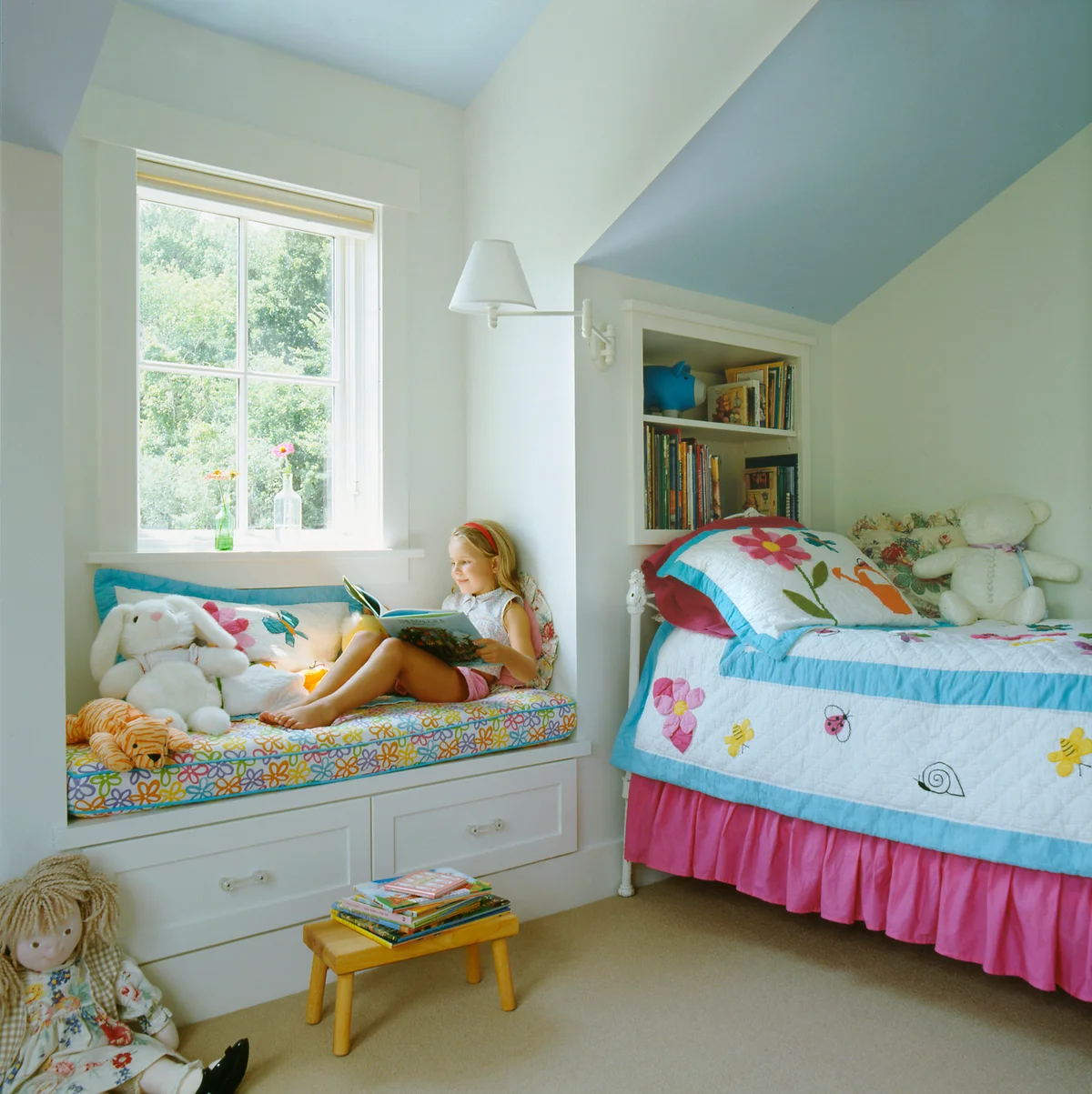 little girl reading on a window seat