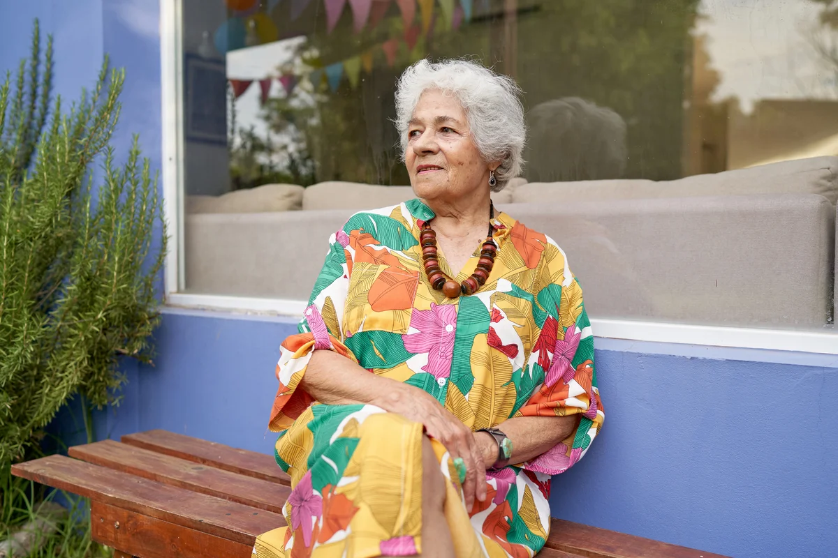 Woman with vintage inspired short hair wearing floral dress sitting outside