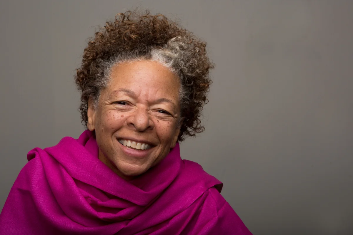 Older woman with short curly cut wearing purple shawl