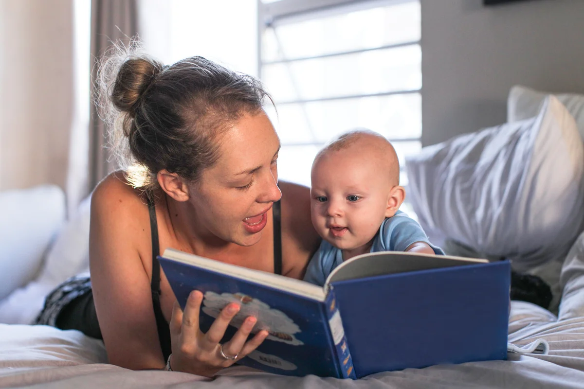 Mother reading book with infant child