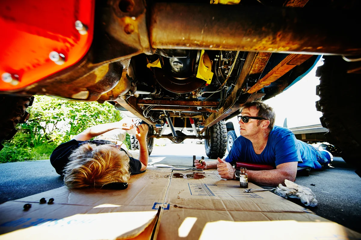 Dad and son working underneath car