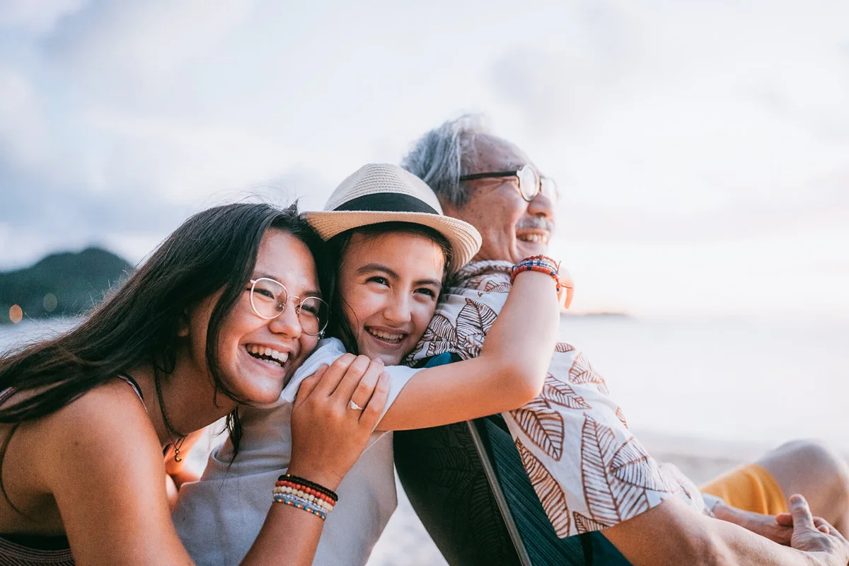 Grandfather and granddaughters having fun on beach