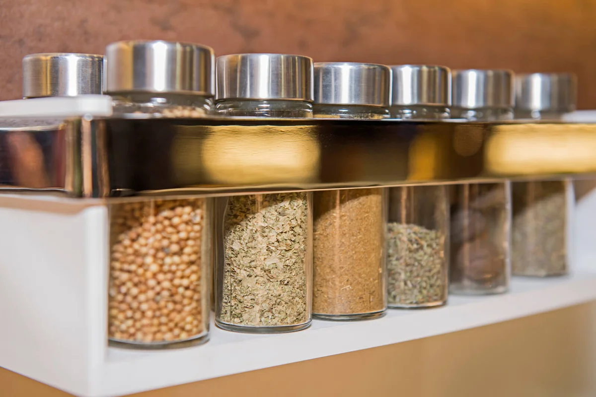 Closeup of kitchen spice rack with jars in a row