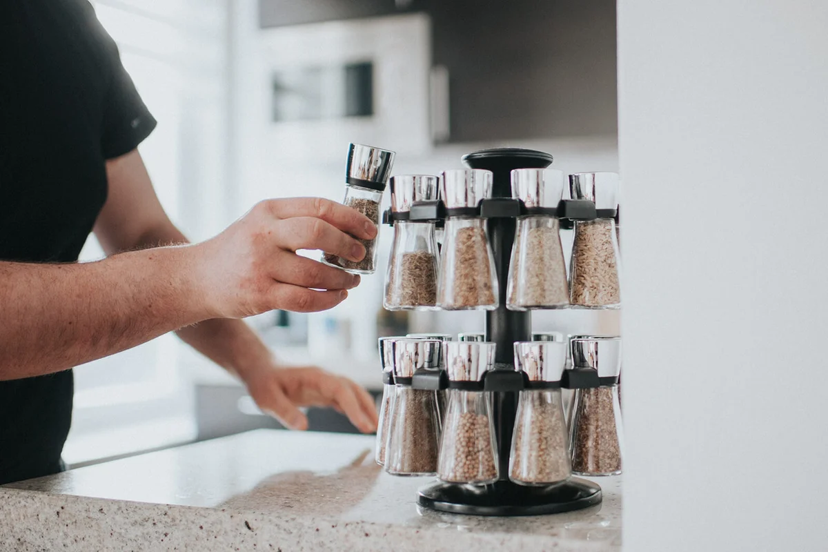 Man reaching for a spice from spice rack