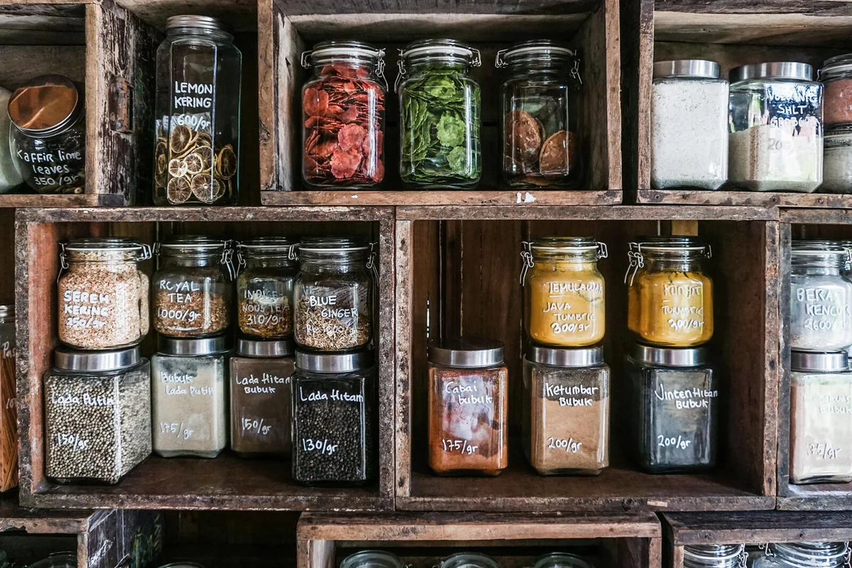 Jars containing spices and herbs in DIY wooden rack