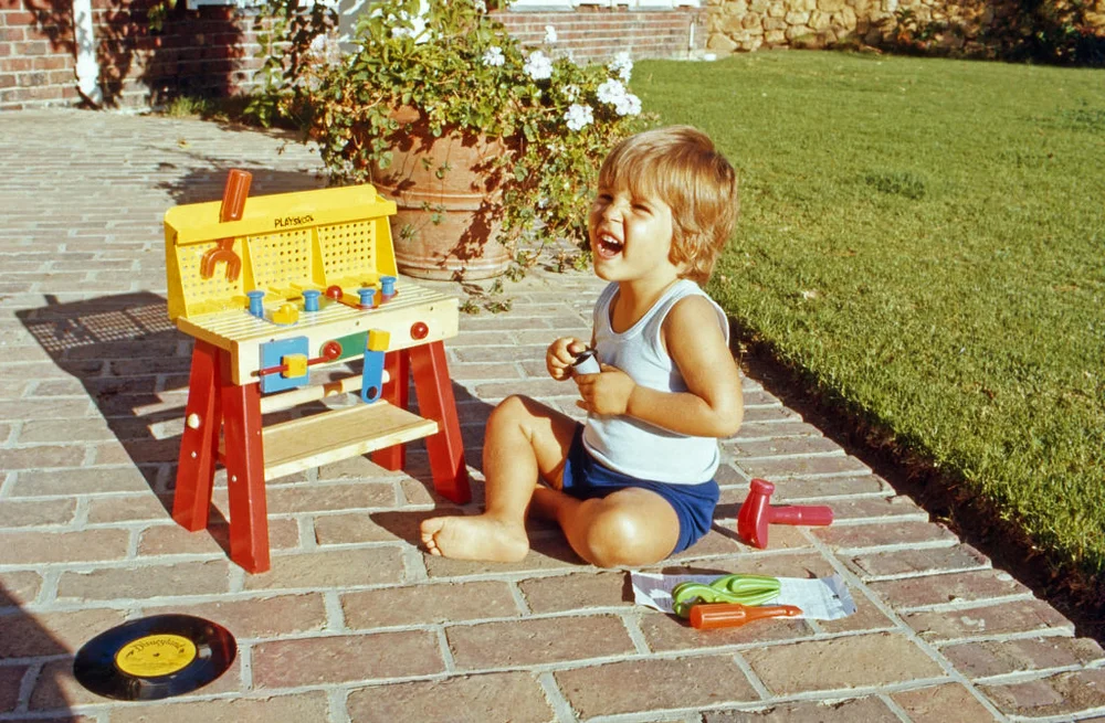 Little kid playing with Fisher Price toy in the 70's