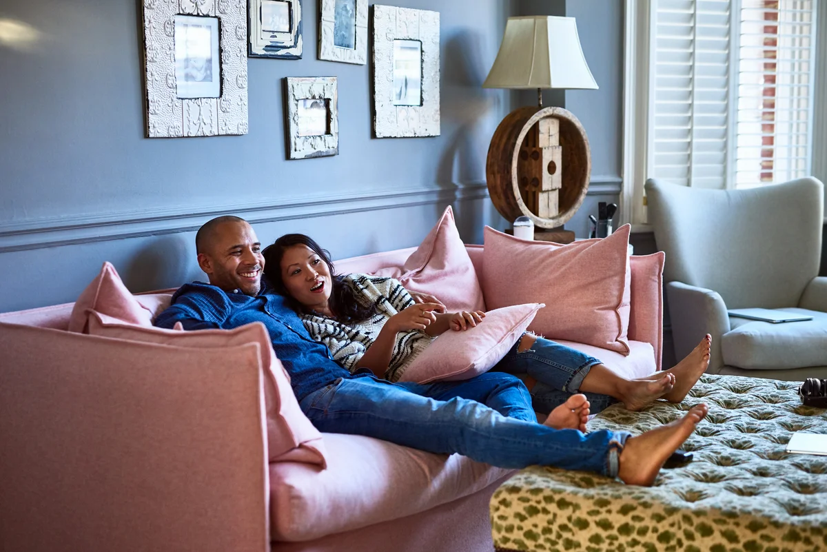 Happy couple snuggled up on couch