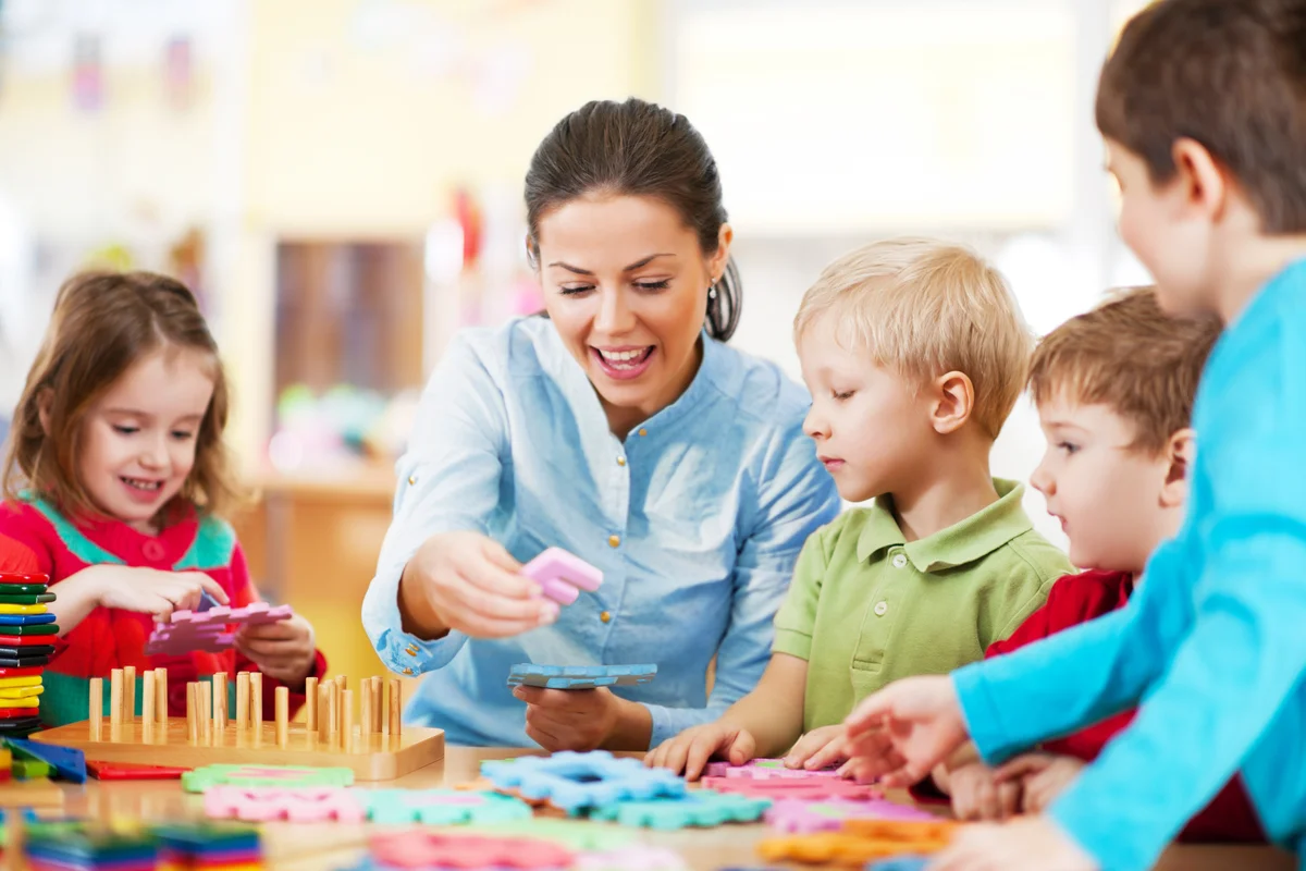 Woman doing puzzle activities with group of children