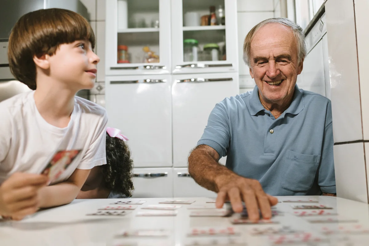 Grandfather and grandson playing concentration with deck of cards