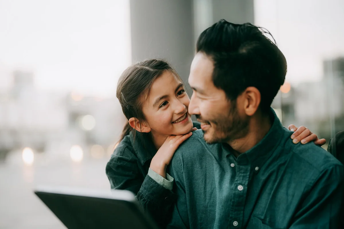 Father and young daughter using digital tablet in city