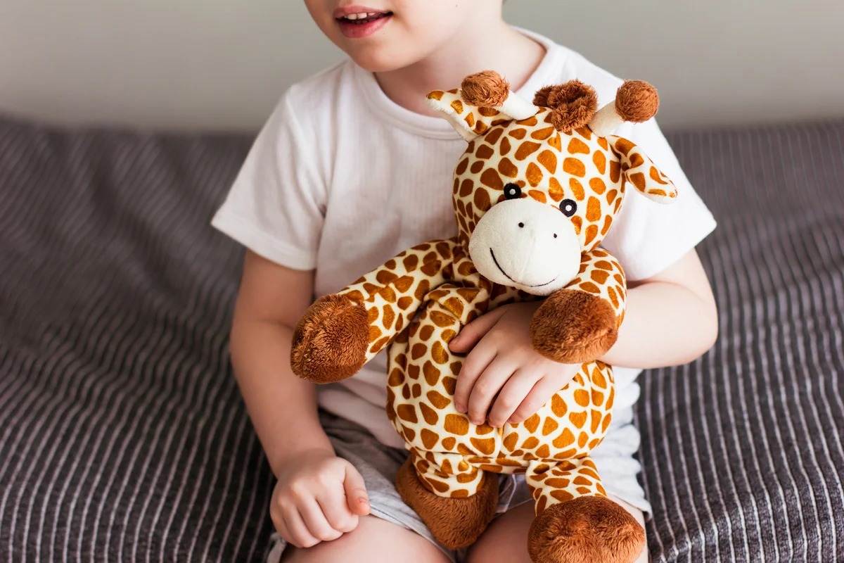 child with stuffed giraffe