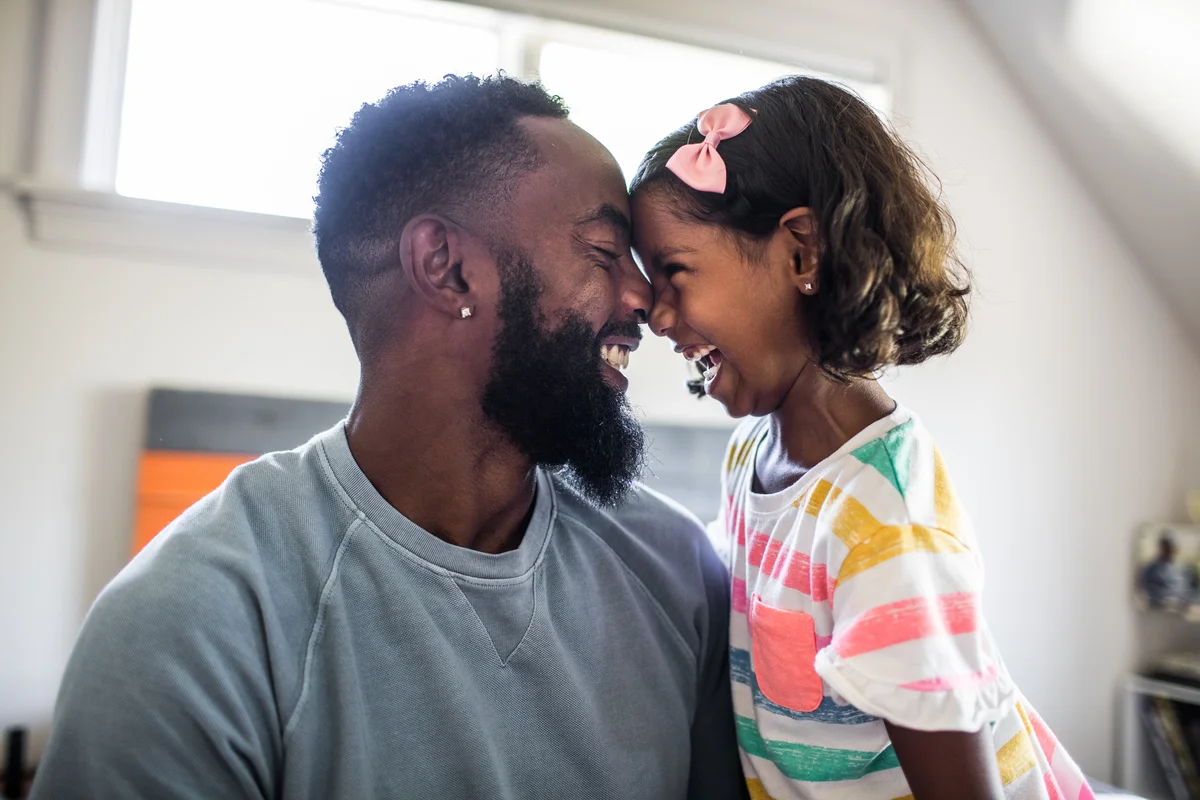 Dad and daughter touching foreheads and laughing