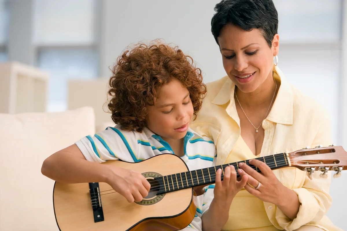Mom and son learning how to play guitar
