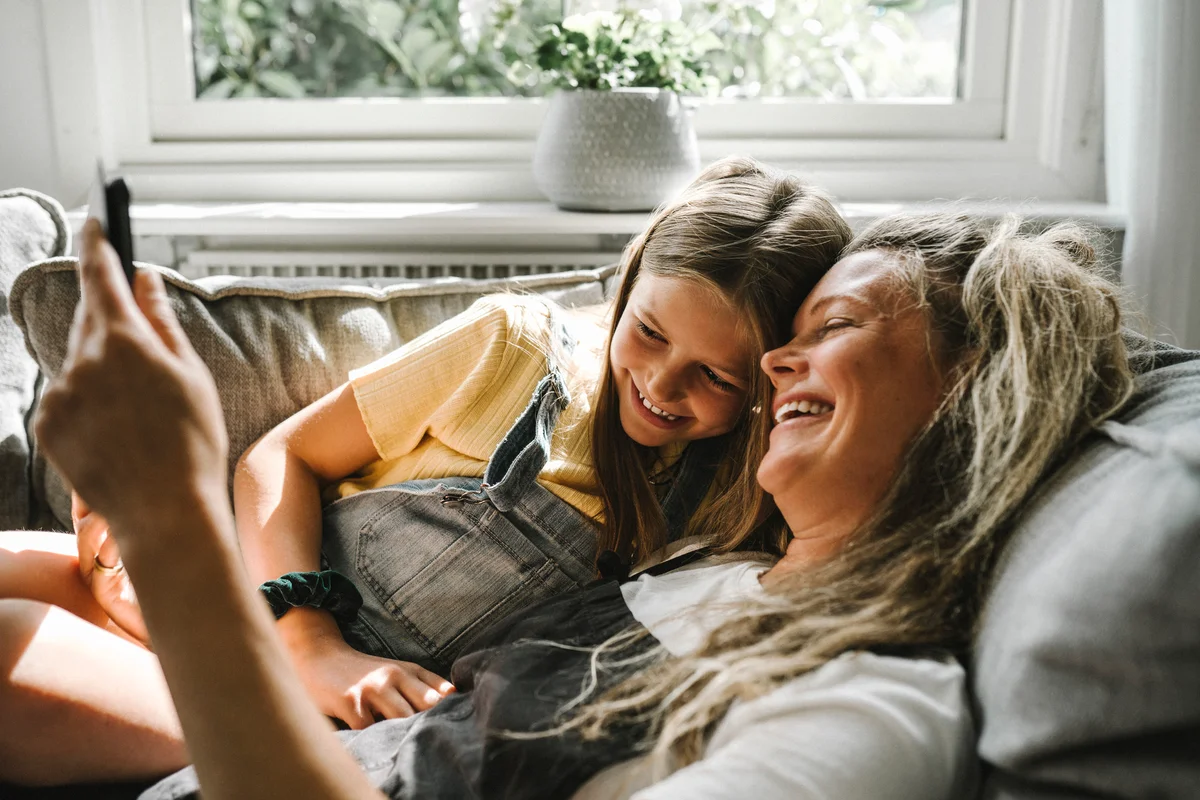 Mom and daughter laughing on couch