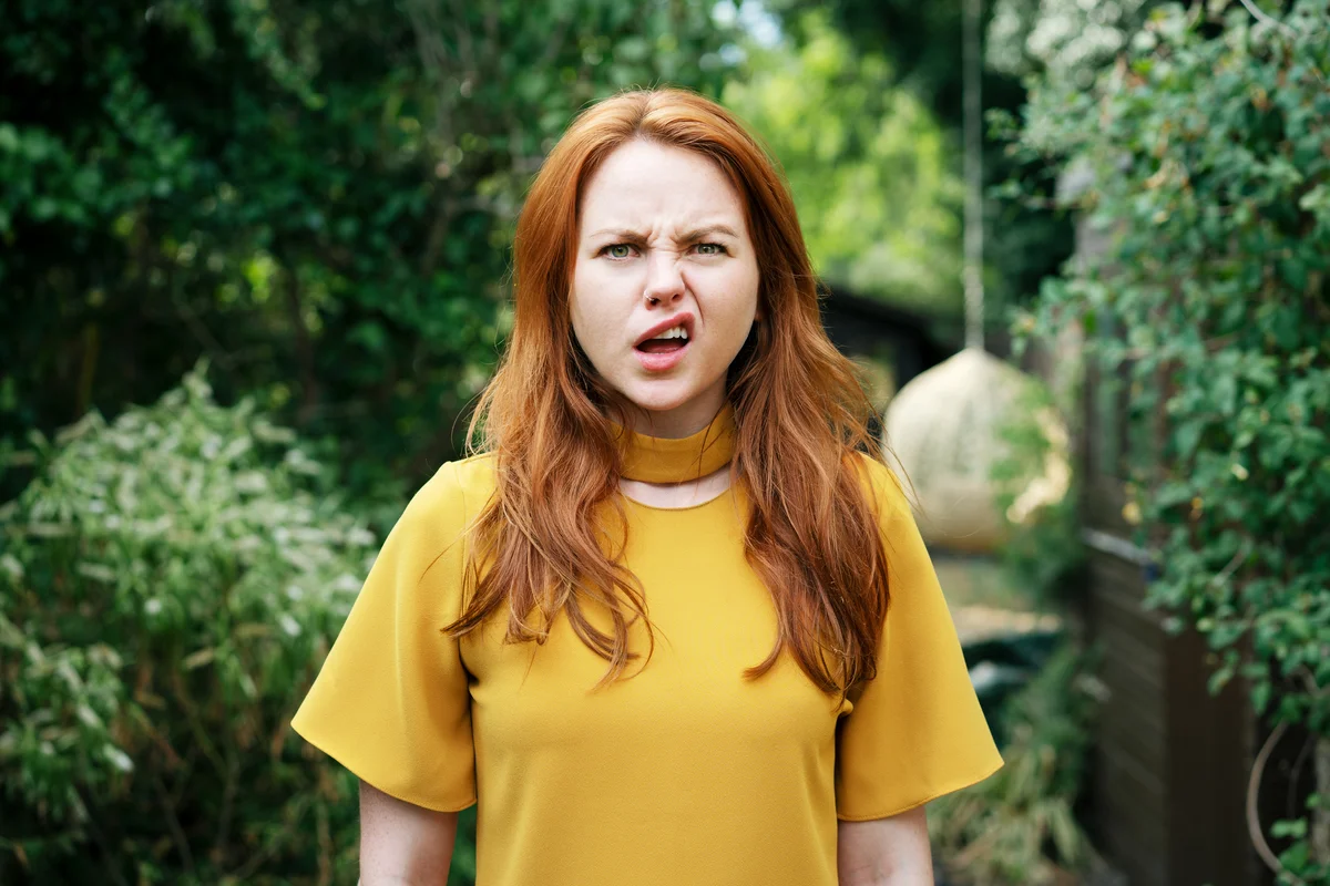 Girl with red hair looking confused and shocked