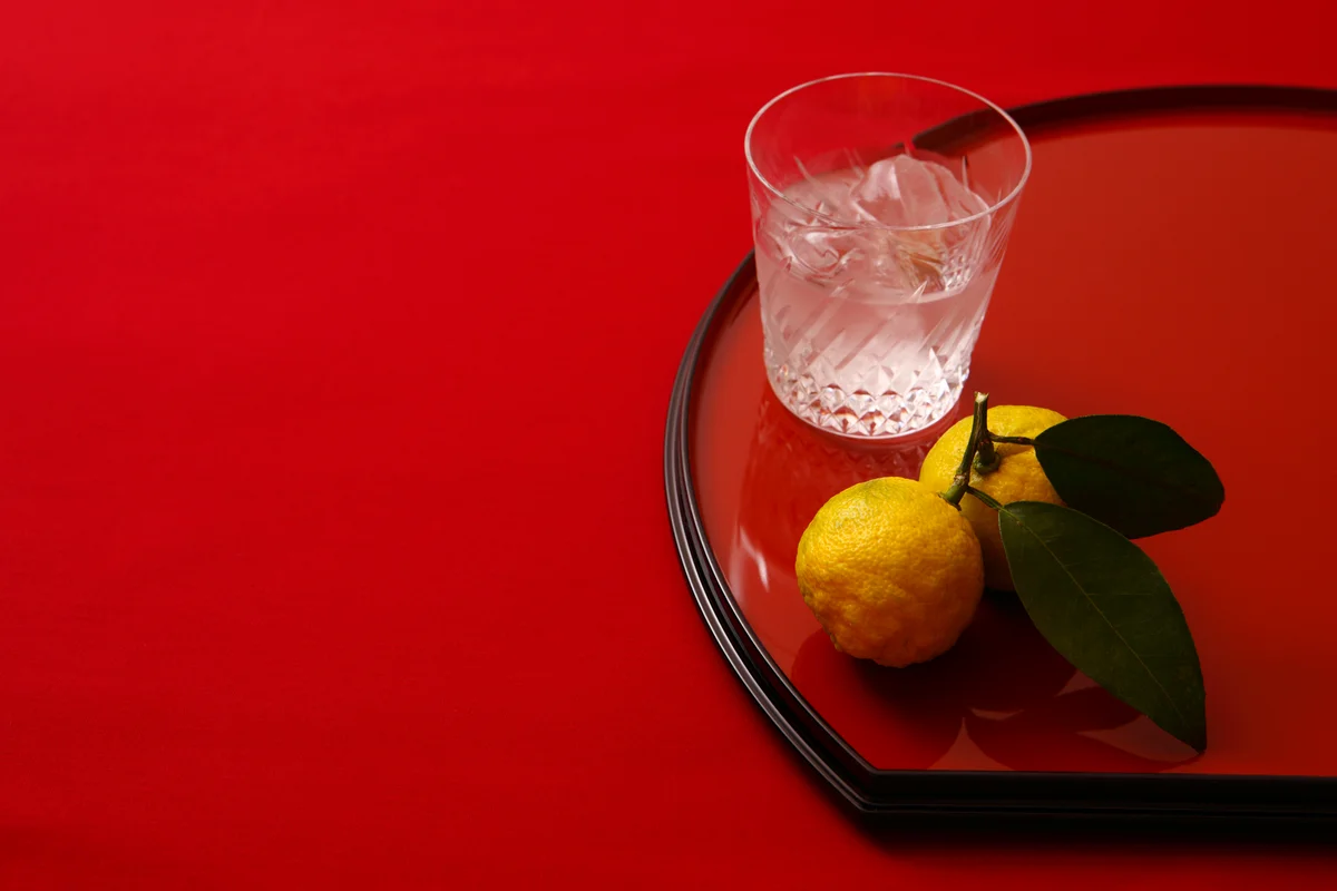 glass of shochu with yuzu on red background