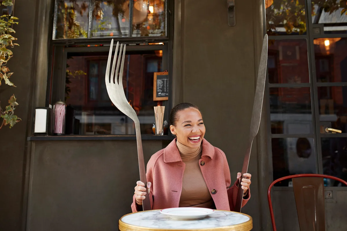 Woman holding giant fork and knife