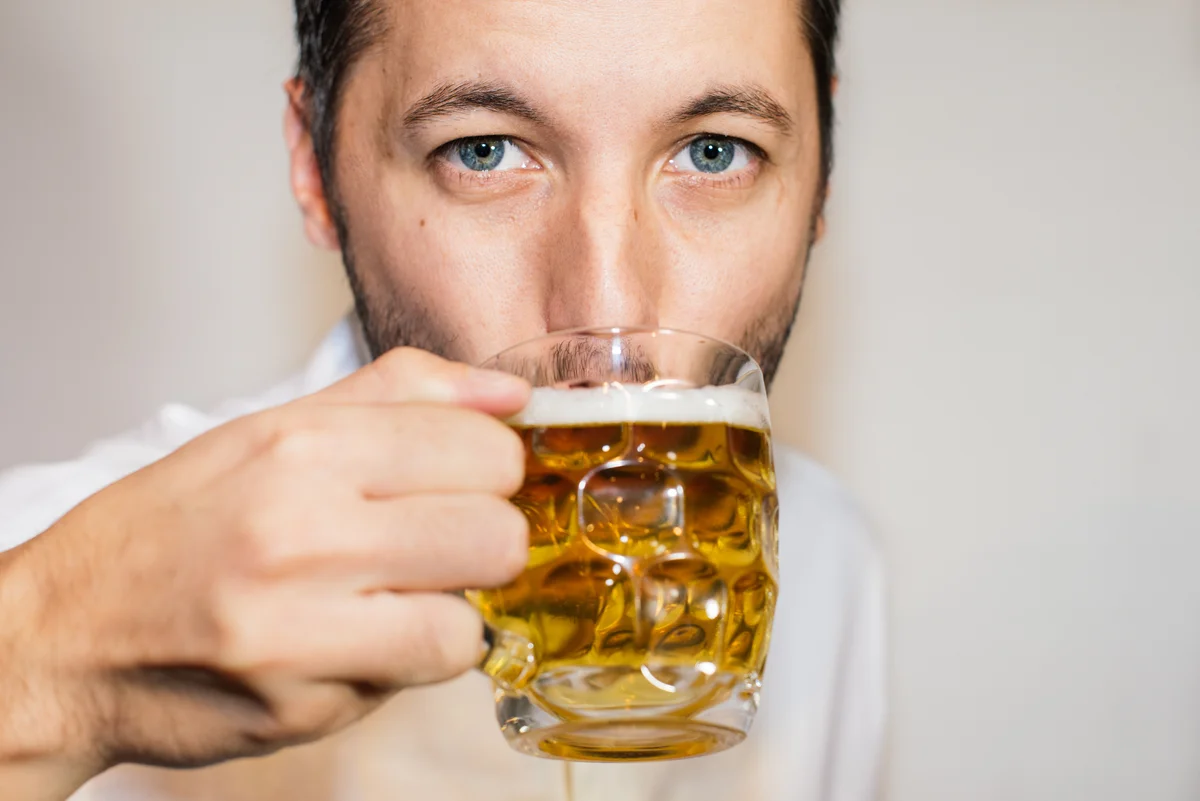 Blue eyed man drinking a beer