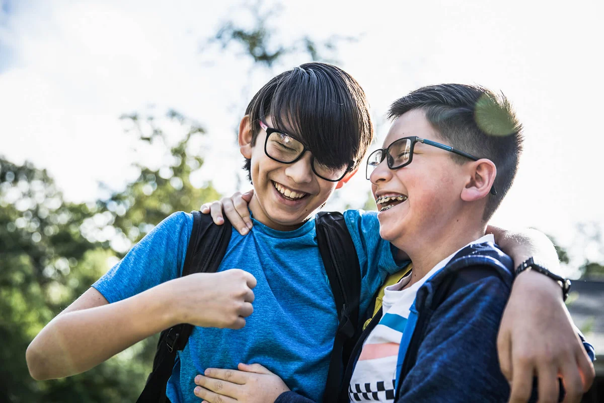 School age brothers laughing outdoors