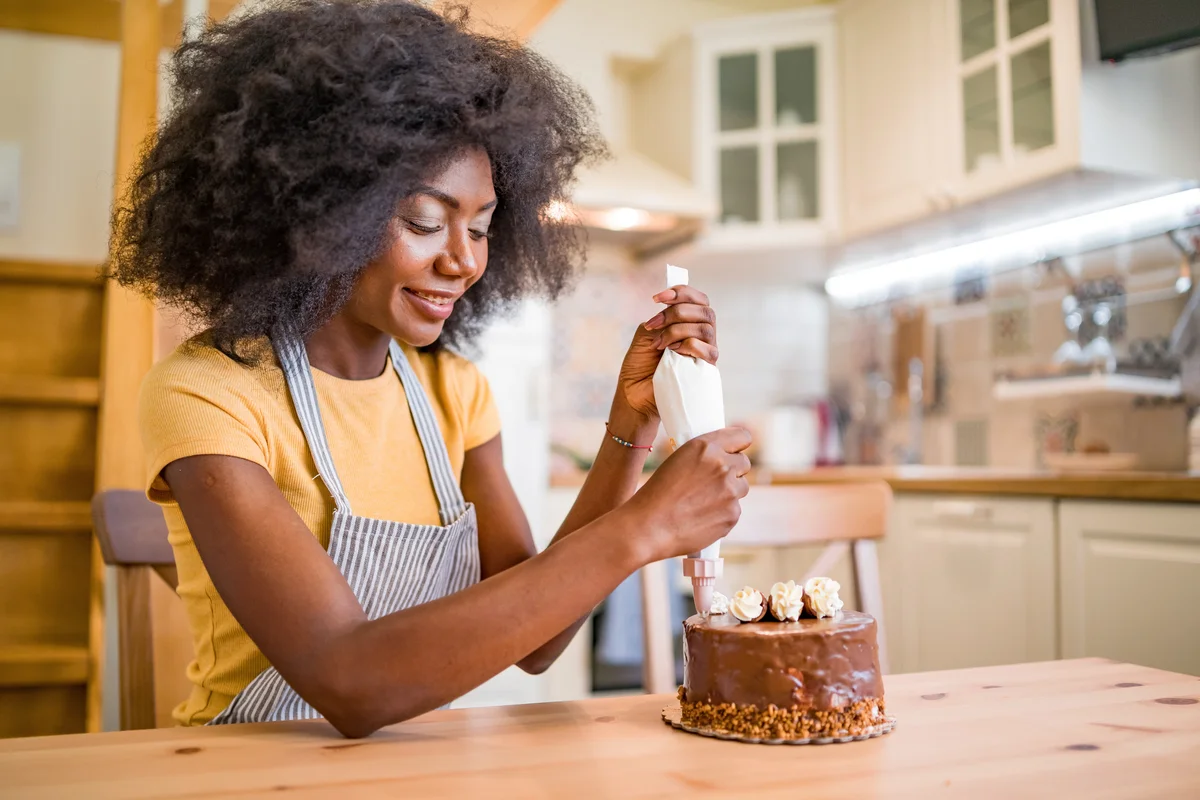 Women decorating a cake at home