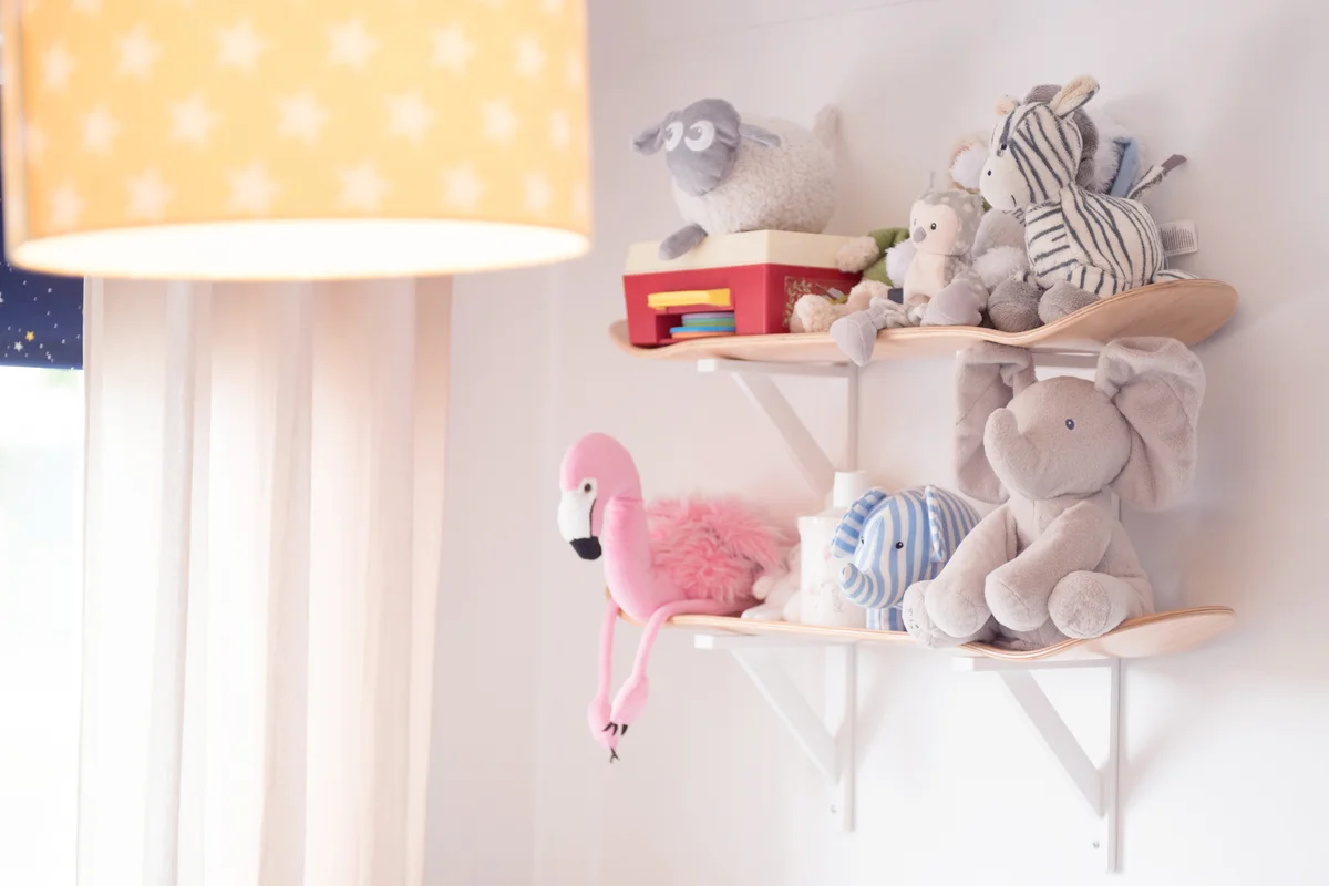 Stuffed animals on a shelf made from skateboards in a nursery