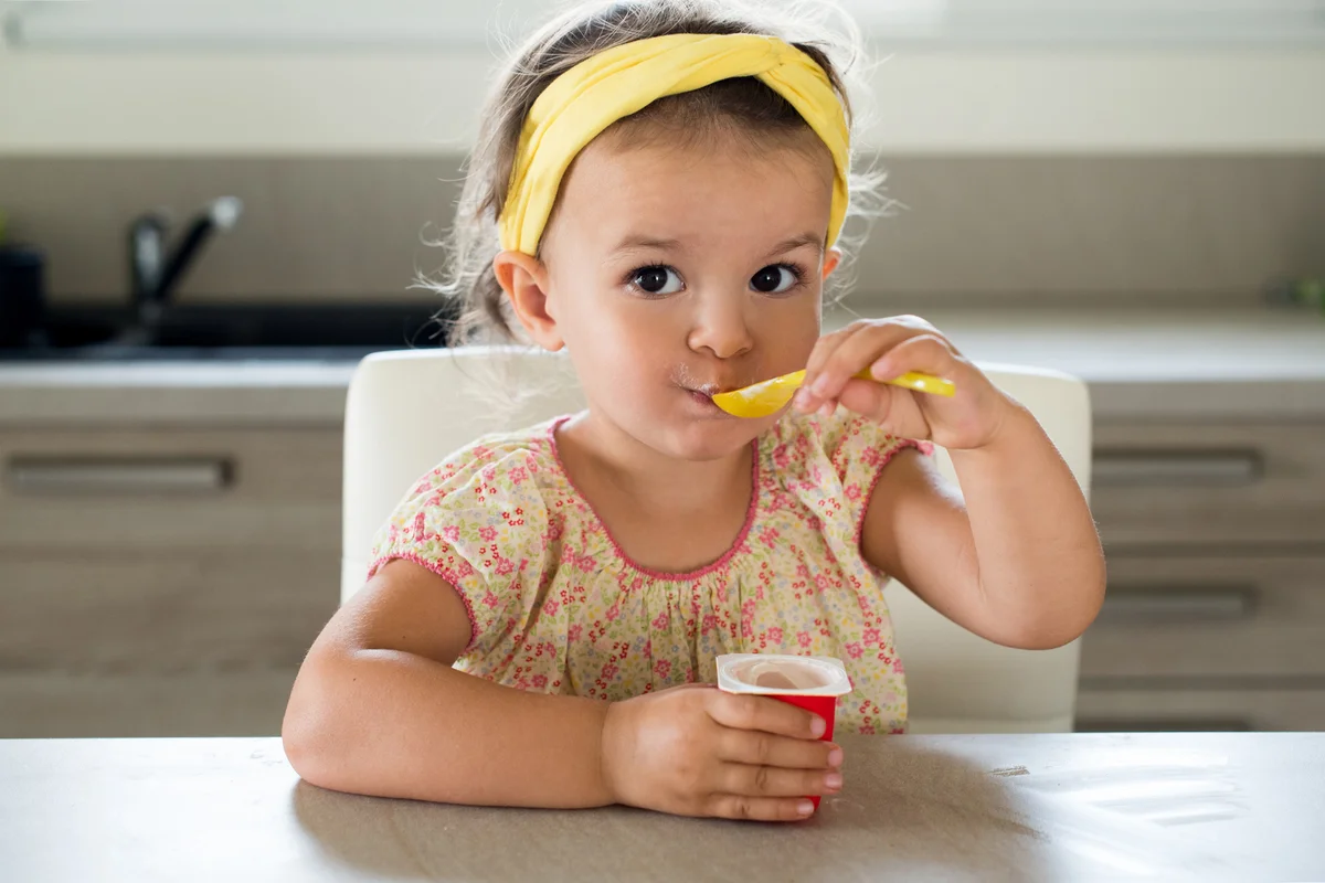 Toddler girl eating yogurt