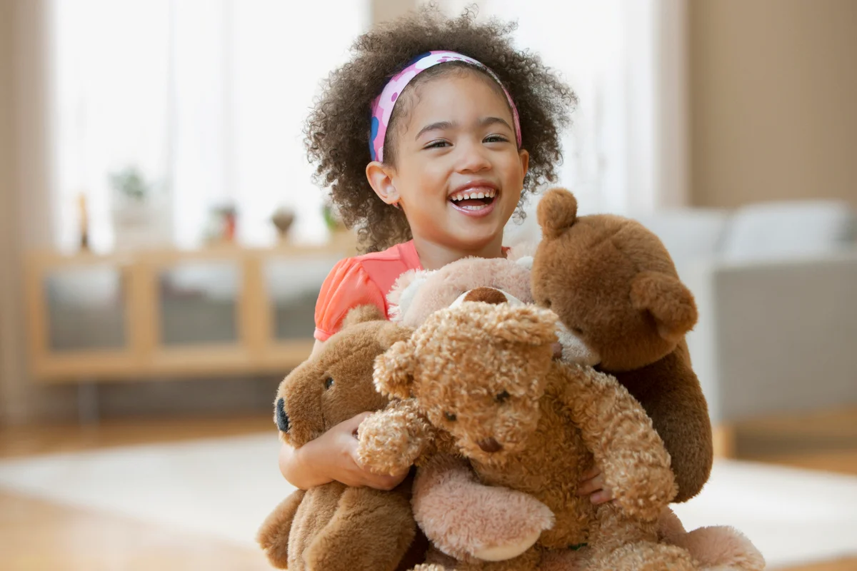 Little girl holding teddy bears