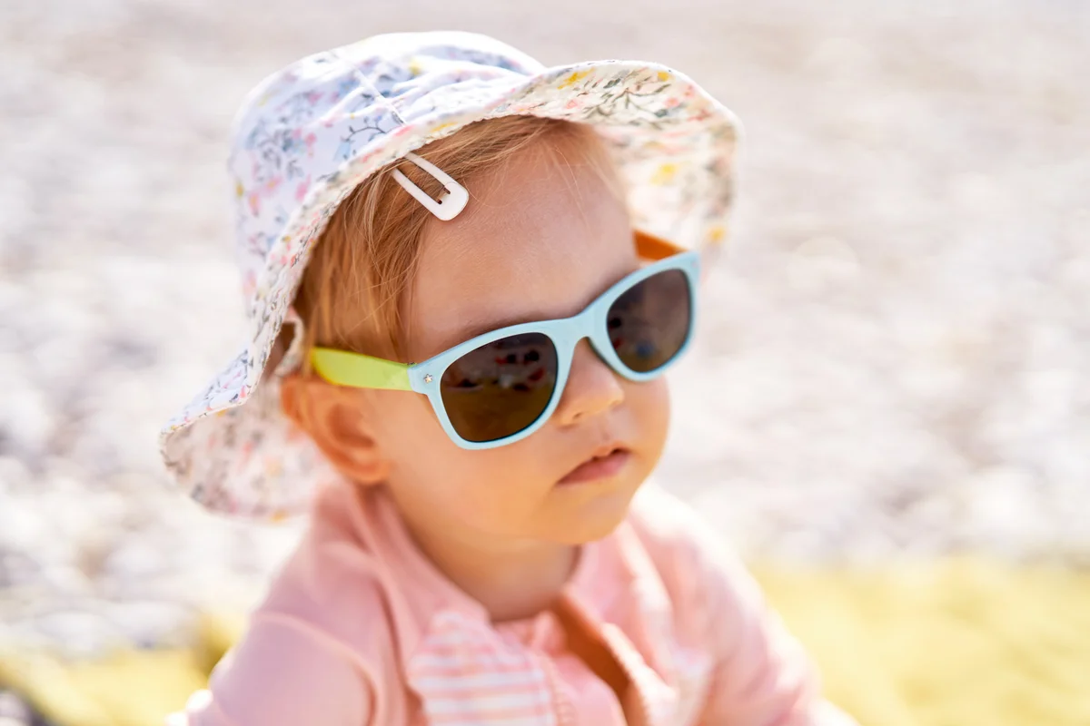 Little girl in sunglasses on the beach