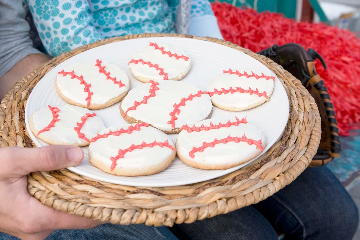 Man holding plate of baseball cookies