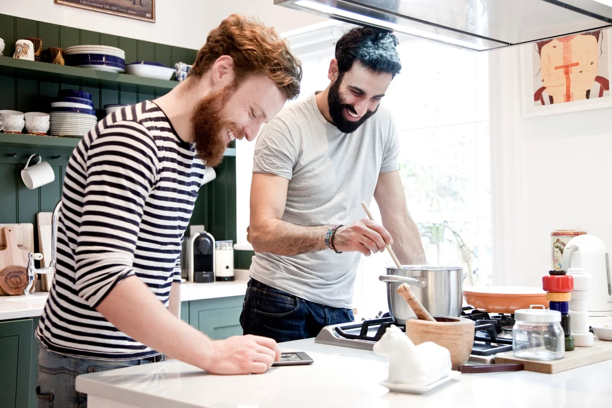 Two men having a cooking date night and looking at recipe