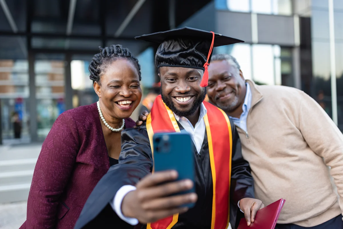 Young man taking graduation photo with his parents
