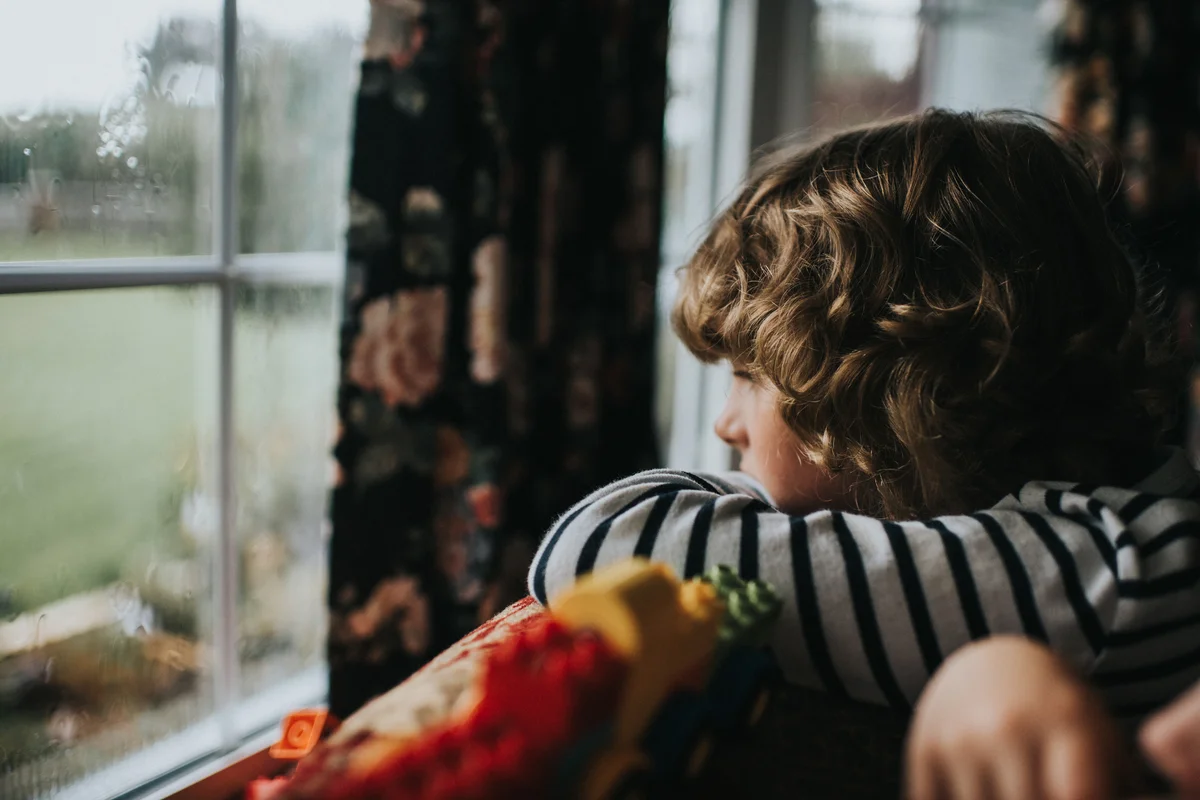 Child watching thunderstorm outside