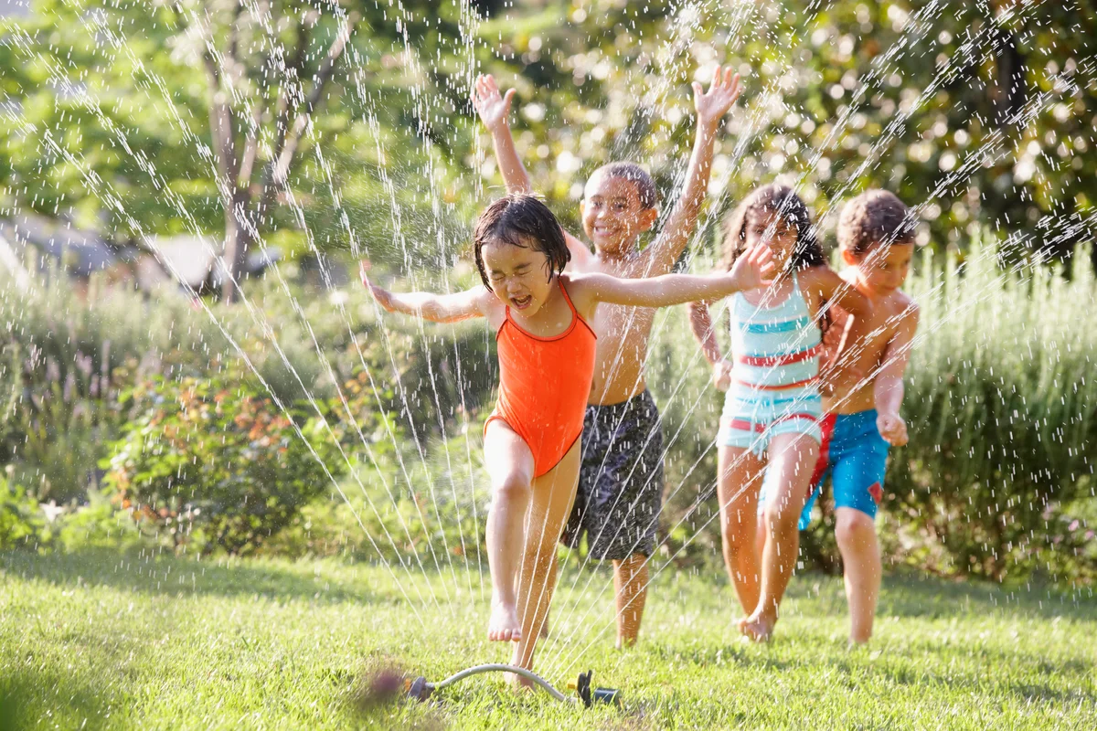 Kids running through the sprinkler