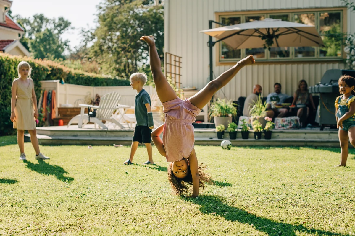 little girl doing cartwheel at backyard party