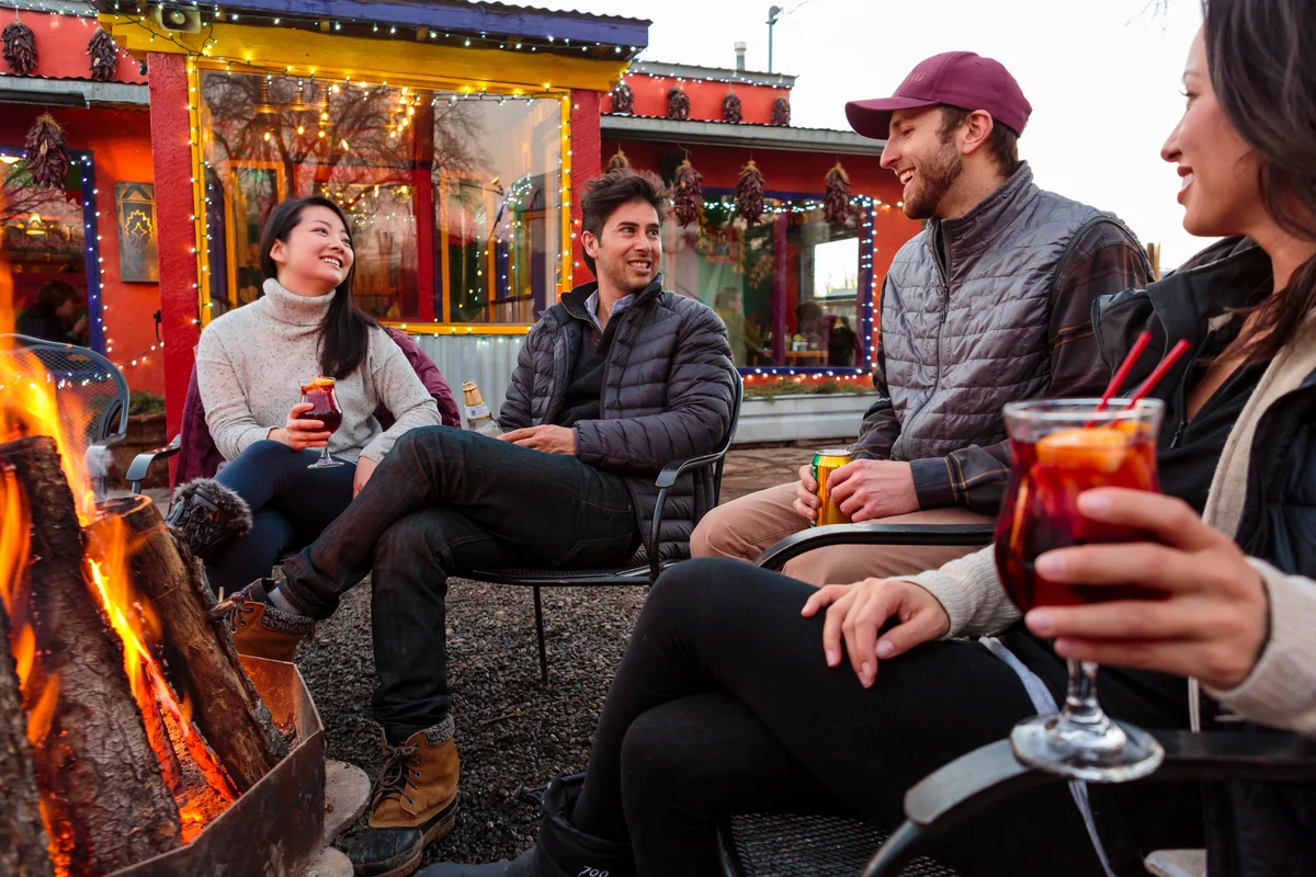 2 New Mexico couples enjoying cocktails and bonfire on outdoor patio bar