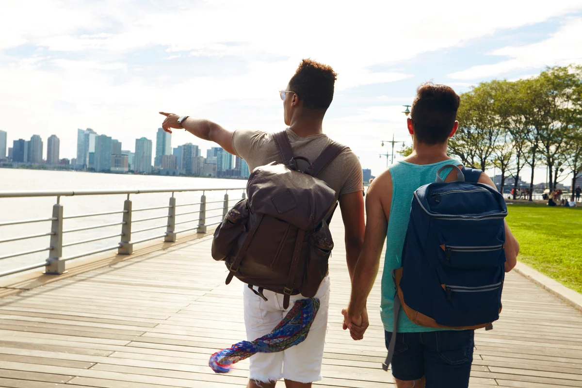 Young male couple walking boardwalk in New York