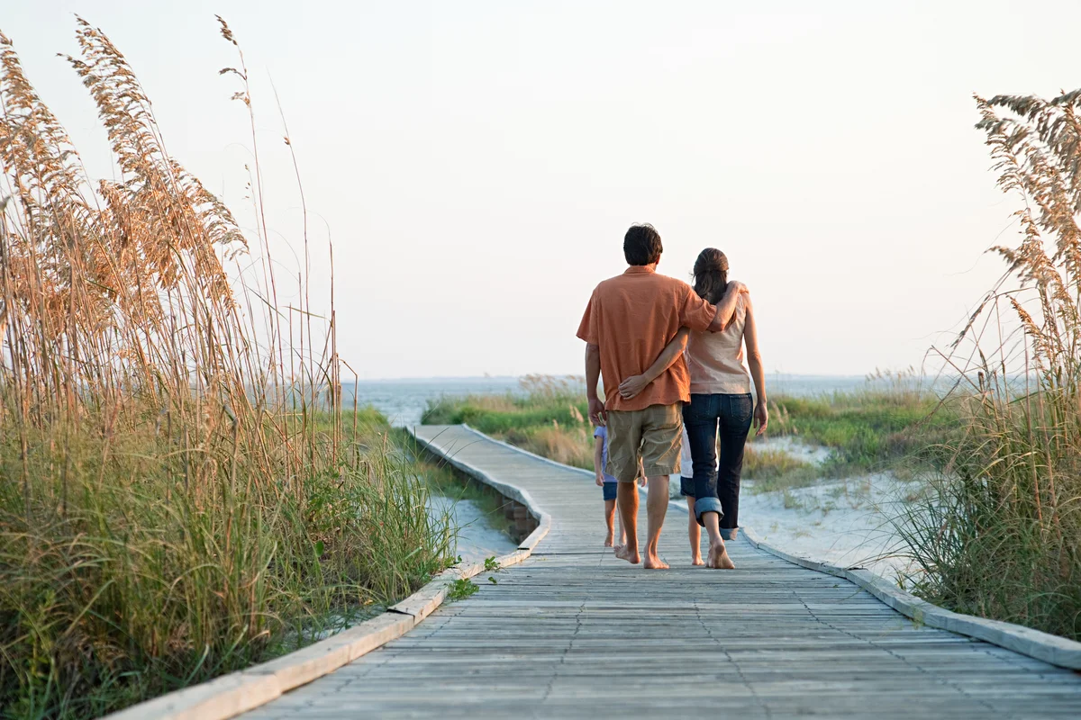 Couple walking boardwalk to beach in South Carolina