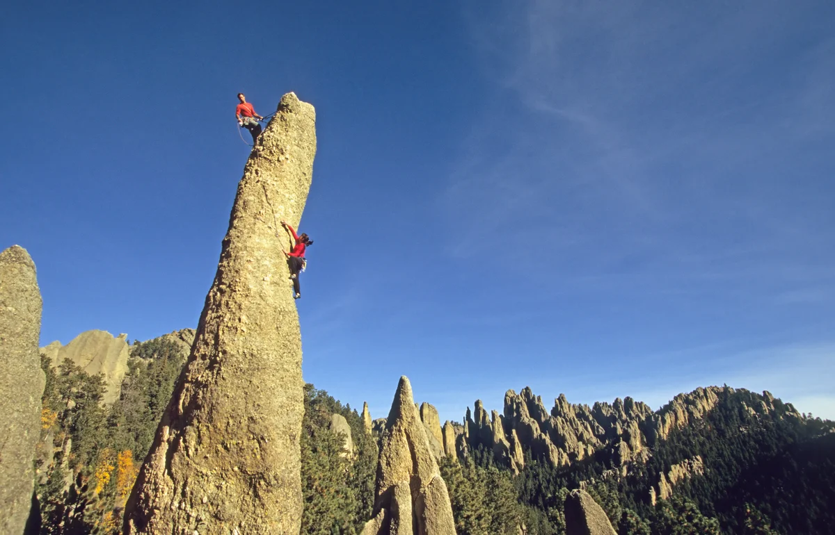 Couple climbing huge rock in South Dakota