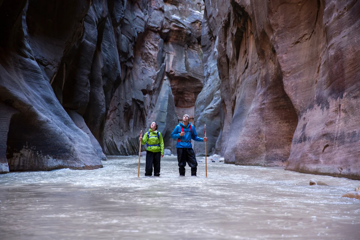 Couple hiking through water in Utah